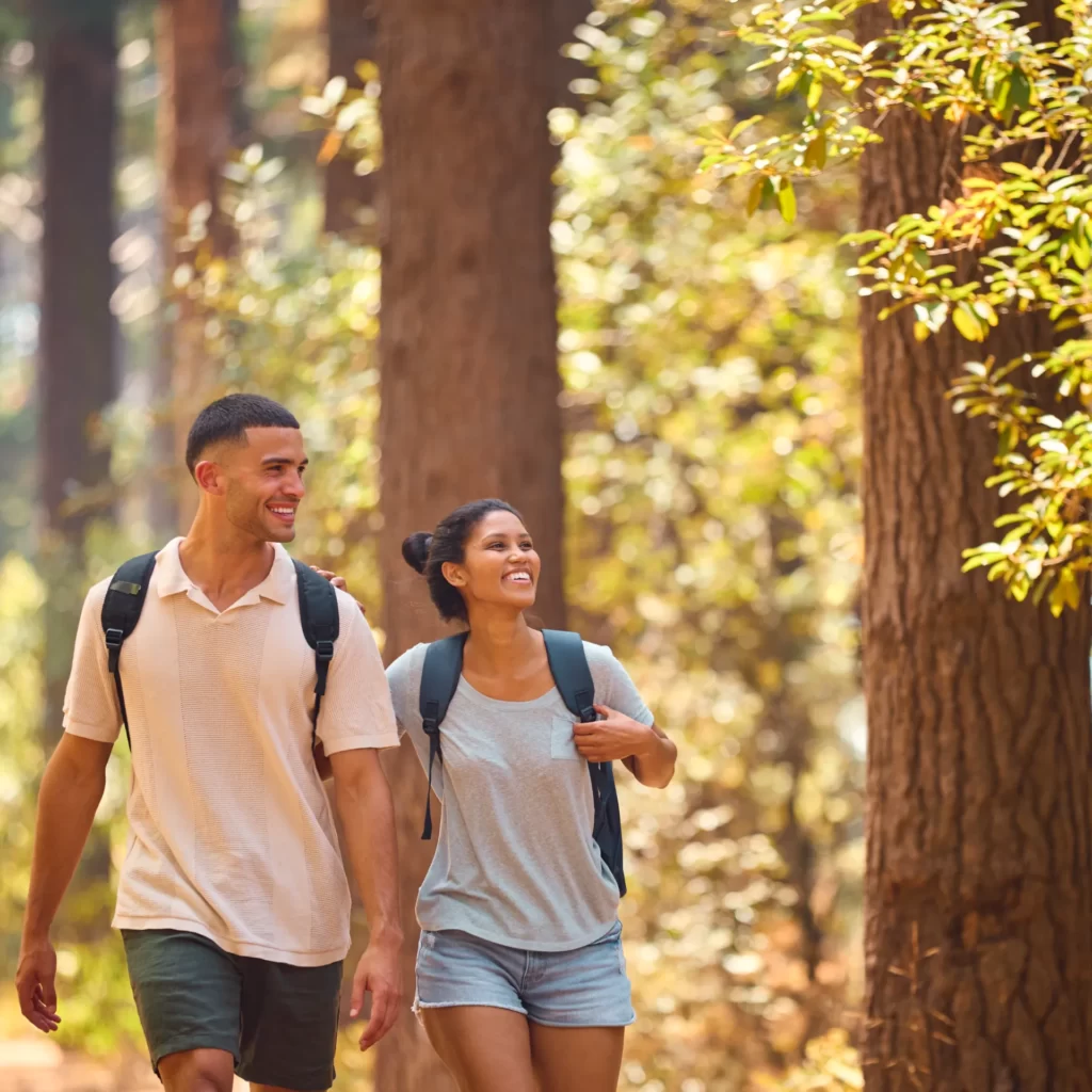 young couple holding hands wearing backpacks hikin utc